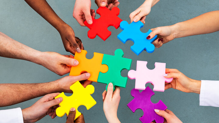 Menschen halten Puzzleteile