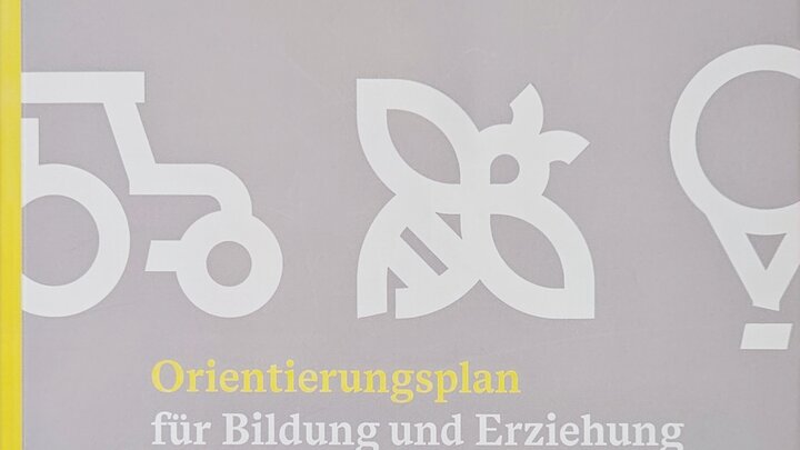 Das Bild zeigt das Cover des weiterentwickelten Orientierungsplans. Die obere Hälfte wird gefüllt durch drei Icons aus dem Landes CD: ein Traktor, eine Biene und ein Ballon. Auf der unteren Hälfte ist zweizeilig Orientierungsplan für Bildung und Erziehung als Titel zu lesen. Im Untertitel ist kleiner zweizeilig in baden-württembergischen Kindertageseinrichtungen und Kindertagespflege zu lesen.